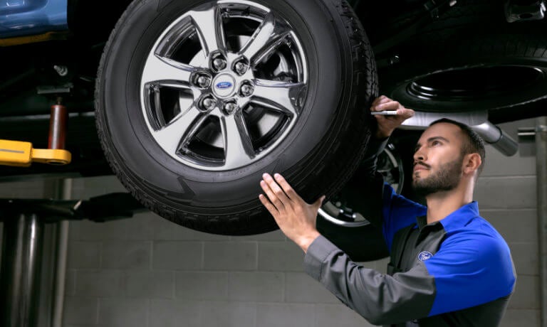 Ford Service Technician Inspecting Tire